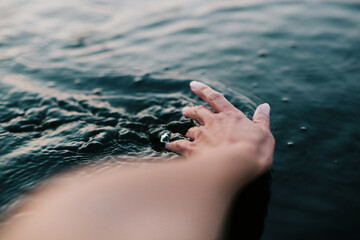 woman's hand touching water