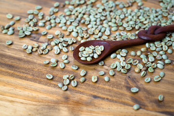 Obraz na płótnie Canvas green coffee on wooden table with spoon