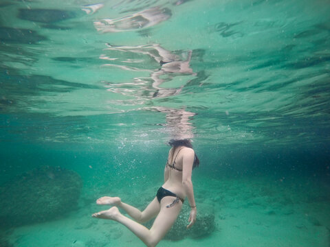 Woman swimming in the ocean underwater