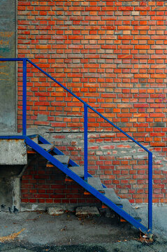 Blue stairs in front of the brick wall