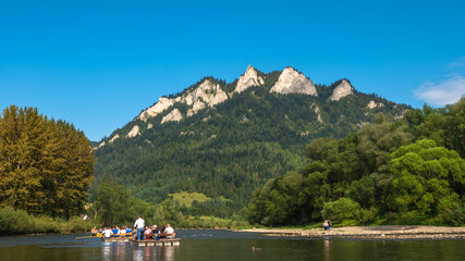 Traditional rafting on the Dunajec Gorge and view of Three Crowns Massif, Pieniny, Poland. © Kamil