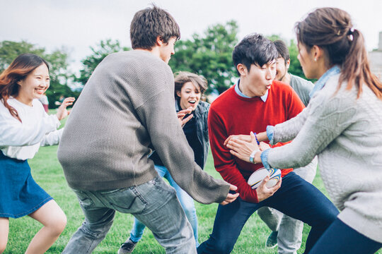 Teenagers Friends Playing Rugby in the Park