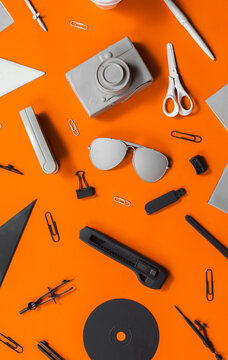Grey black and white office stuff on orange background