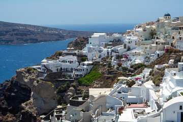 Beautiful view of  Oia, the famous town with its typical white houses on a sunny day.  Santorini island, Cyclades, Greece, Europe.