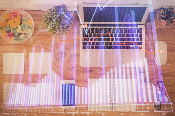 Stock market graph and top view computer on the table background. Multi exposure. Concept of financial education.