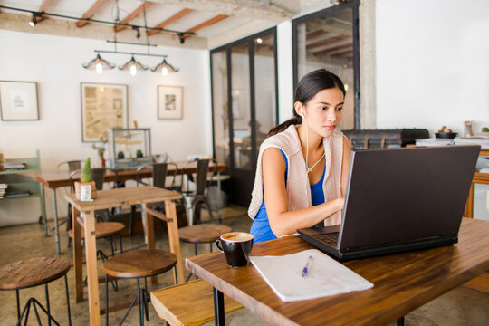 Young business woman working with laptop in coffee shop