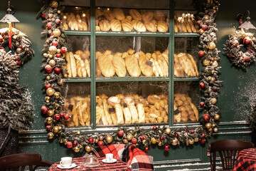 Old bakery window on Christmas Eve. Freshly baked bread sold on a bakery showcase. Christmas celebration.