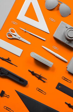 Office supplies and stuff arranged on orange backgorund.