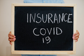 Insurance covid. Coronavirus concept. Boy hold inscription on the board.