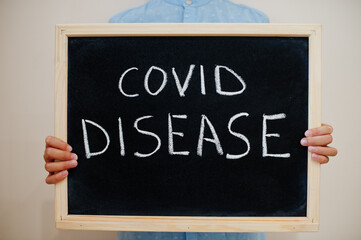 Covid disease. Coronavirus concept. Boy hold inscription on the board.