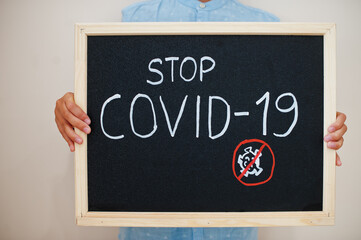Stop Covid-19. Coronavirus concept. Boy hold inscription on the board.