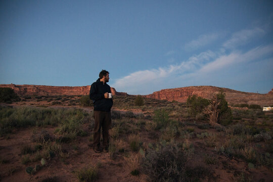 Man drinking coffee at sunrise in the Moab Desert