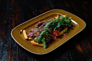 Grilled meat with french fries and greens. Fast food with restaurant serving.