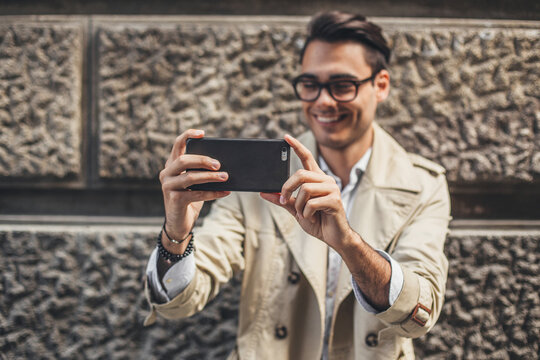 Stylish Man Taking Picture With His Mobile Phone.