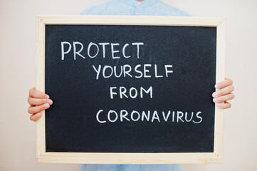 Protect yourself from Covid. Coronavirus concept. Boy hold inscription on the board.