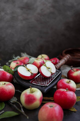 Lots of small apples in wooden bowls. Autumn harvest of fruits on a dark background.