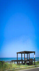 Unrecognizable man sitting in a wooden construct on the shore of the sea in Italy.