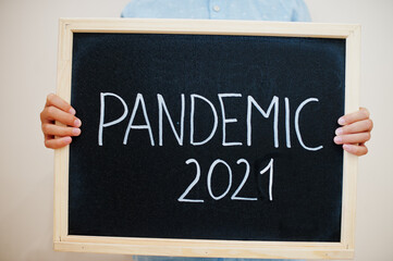 Pandemic 2021. Coronavirus concept. Boy hold inscription on the board.