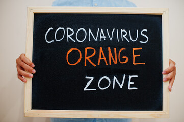 Orange zone. Coronavirus concept. Boy hold inscription on the board.