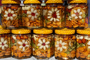 Glass jars with honey and nuts on the market counter.