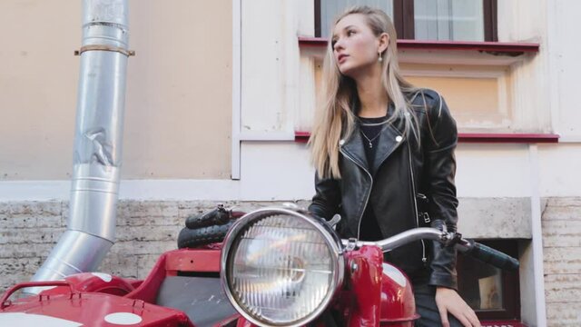 Attractive young girl sexy sits riding a red motorcycle adventure glamour