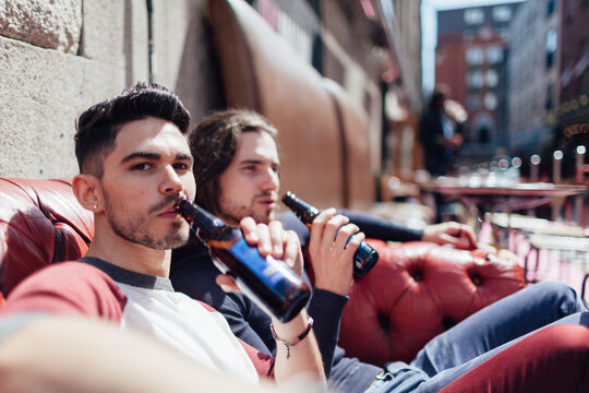 Two happy friends laughing and enjoying a beverage on a sailboat