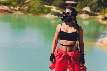 Woman dressed in a steampunk suit in a defiant attitude with her arms crossed. respirator on the...