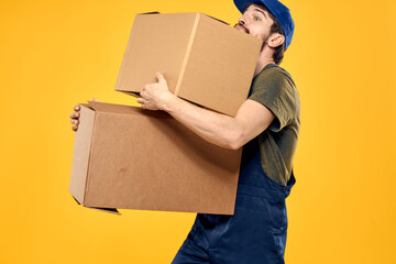 A man in a working form a box with loading tools yellow background