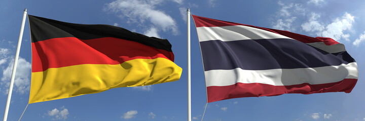 Waving flags of Germany and Thailand on flagpoles, 3d rendering