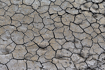 Part of a huge area of dried land suffering from drought in cracks..