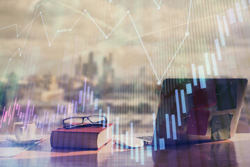 Double exposure of financial chart drawings and desk with open notebook background. Concept of forex market