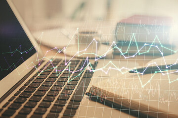 Double exposure of financial chart drawing and desktop with coffee and items on table background. Concept of forex market trading