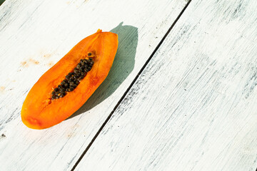Pomarańczowa papaja, tropikalny owoc na jasnym tle.
