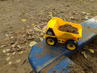 Children's toy car in the sandbox. Early child development. Outdoor games.