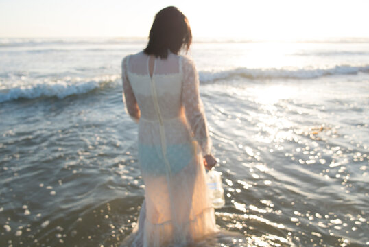 sad lady in wedding dress in the ocean water
