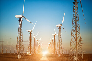 Beautiful sunset above the windmills on the field.Windmills for electric power production