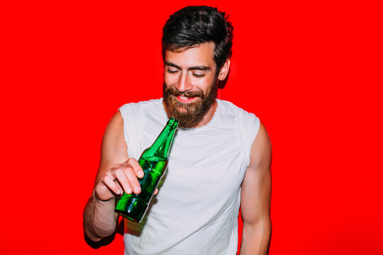Man with beer bottle smiling.