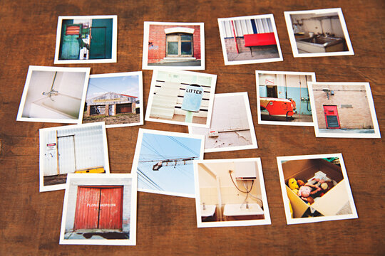 wooden tabletop with a collection of small medium format prints