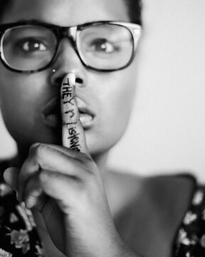 Paranoid African Woman with Finger Over Mouth