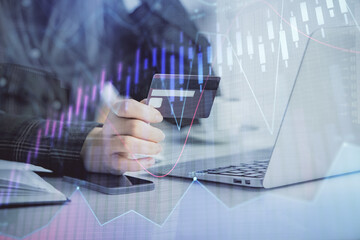 Multi exposure of woman on-line shopping holding a credit card and financial graph drawing. Stock market E-commerce concept.