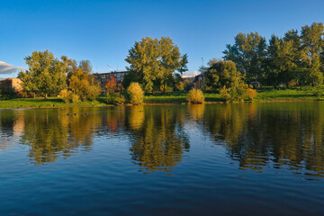 Autumn landscape in a city park on the river bank.