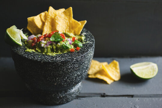 Guacamole and nacho chips on a table.