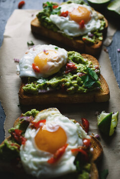 Avocado and fried egg toasted open sandwiches.