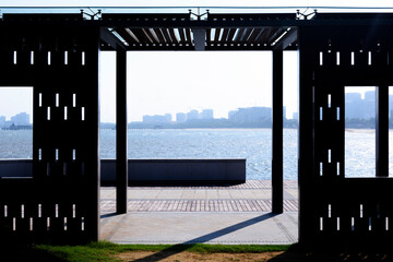View of the sea on seashore through pavement in garden