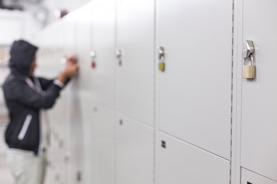 Thief With Black Hoodie Trying To Open Padlock