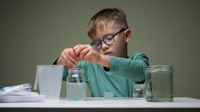 Home schooling concept. First school day. Young boy doing his school homework. Pupil doing school homework. Conduct an experiment concept. Successful young boy. Successful pupil. Studying indoor