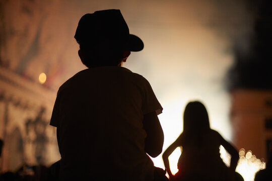 Silhouette of two children in a fire parade