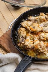 prepared chicken wings at frying pan on a wooden desk. domestic cooking