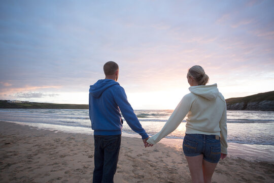 Couple on beach at sunset.