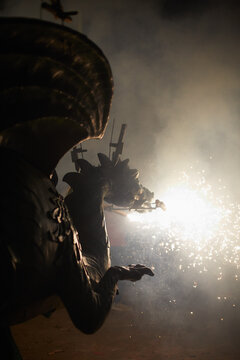 Silhouette of dragon spitting fire in a street parade